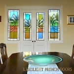 Bevelled clear glass shapes akin to palm fronds superimposed on colored background.