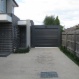 A motorised roller door fitted to a carport with two 150mmx50mm RHS galvanized steel jambs, later painted monument